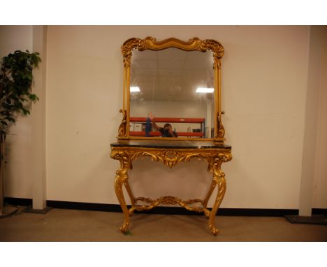 A second half 20th century gilt console table and mirror, the rococo style ornate base with shaped black and white marble top