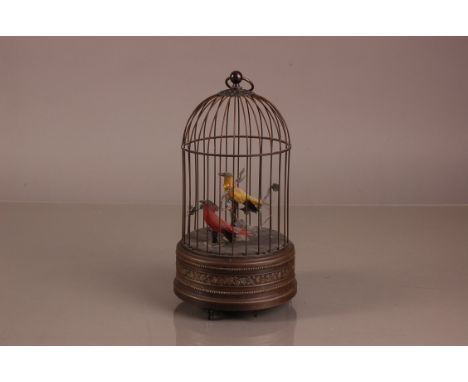 A late Victorian bird cage automaton, 27cm high, with yellow and red bird in the cage, appears to function but needs cleaning