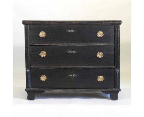 A 19th century continental ebonised chest, containing three long drawers, with brass portrait medallion handles, between reed