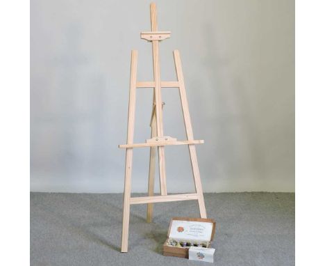 A pine artist's easel, 147cm high, together with a box of fabric paints