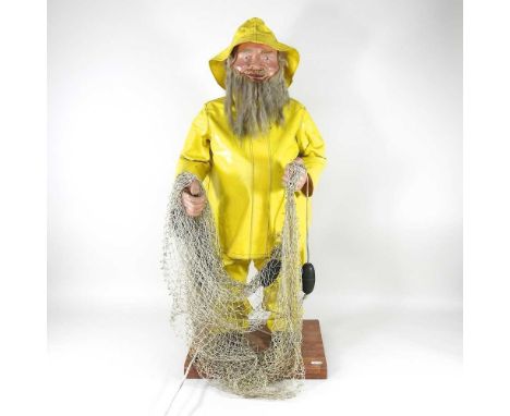 An automaton figure of a fisherman, with a white beard, wearing a yellow raincoat, bearing a label for J.H. Animations, 82cm 