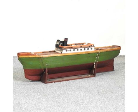 A green painted wooden model boat, on stand, 110cm long