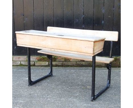 A vintage double school desk, with a bench seat and iron frame102w x 69d x 74h cm