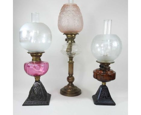 A 19th century brass oil lamp, with a stone column and opaque glass shade, 65cm overall, together with two various cast iron 