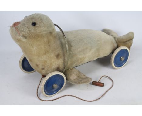 Steiff - A vintage Steiff Pull Along Seal. The blond mohair seal measures approximately 77 cms (nose to tail) and sits on a b