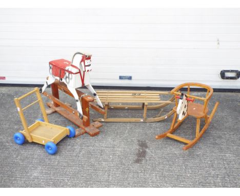 A collection of 2 wooden rocking horses, a sled and a trolley. All wooden and playworn as pictured. This does not constitute 