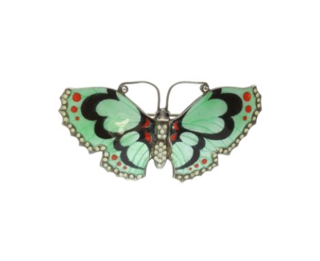 An antique enamel butterfly brooch in silver the body and wings decorated in various colours of green, red, black and white e