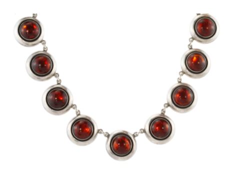 A vintage amber and enamel necklace in sterling silver designed as a single row of thirteen circular links set with amber cab