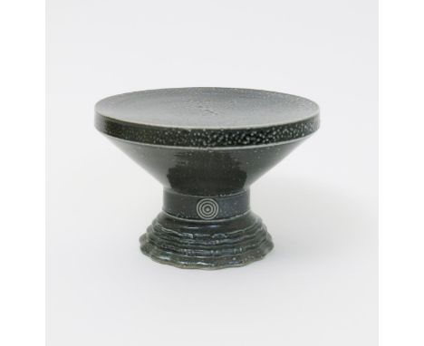 ‡ Walter Keeler (born 1942) a salt-glaze stoneware pedestal, fluted foot supporting flaring top, covered in a blue glaze impr