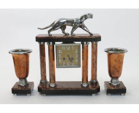 A copper and chromed metal clock garniture, the central clock with four faceted copper columns supporting slate and marble pe