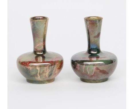 A pair of Wilkinson Oriflamme bottle vases designed by John Butler,  compressed bodies with cylindrical neck, in coral on a g