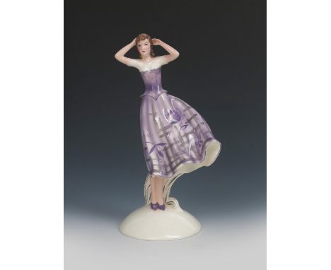 A Goldscheider Pottery model of a woman,  model no.6392, modelled standing her dress blowing in the wind, painted in shades o