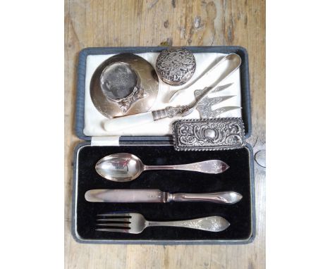 Assorted hallmarked silver comprising a christening set, an inkwell stand, sugar tongs, a brea fork, and two jar tops.  