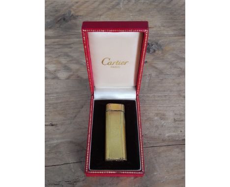 A vintage Cartier gold plated textured lighter in box.  