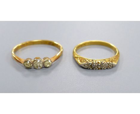 An 18ct gold three-stone diamond ring and another similar ring, gross 5.2 grams.