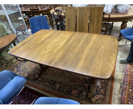 An Ercol Golden Dawn elm extending dining table, length 250cm extended (three spare leaves), width 100cm, height 74cm