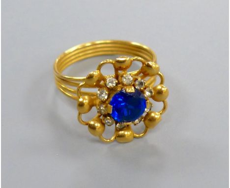 A Middle Eastern yellow metal ring, set with a blue and white paste stones, size O/P, gross 4.8 grams.