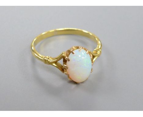 A yellow metal and cabochon oval white opal set dress ring, size O, gross 2.7 grams.CONDITION: A few minor surface scratches 