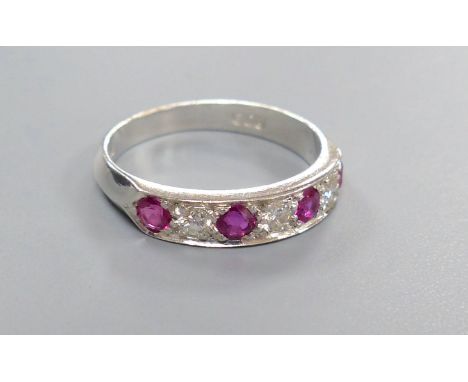 A modern 18ct white gold, four stone ruby and three stone diamond set half hoop ring, size M, gross 3.7 grams.