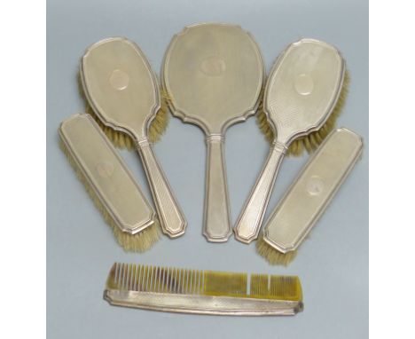 A six-piece engine-turned silver-mounted dressing table set, comprising two pairs of brushes, a comb and a hand mirror, Birmi