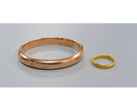 An 18ct gold wedding band, 6.1 grams and a 9ct gold hinged bangle, 12.3 grams.
