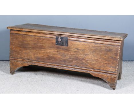 Late 17th/Early 18th Century Elm Plank Coffer, the plain lid with moulded edge, the front panel with conforming moulded decor