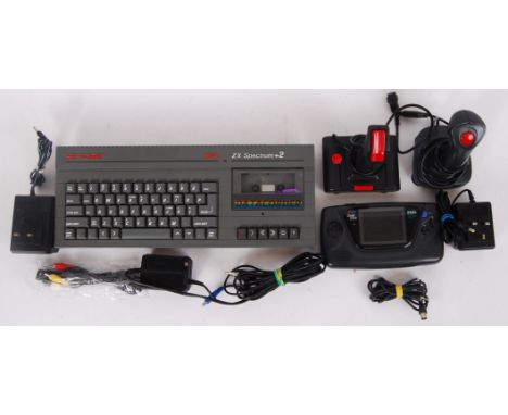 A set of retro 1980's/90's game console controllers including a Sinclair 2x Spectrum Data recorder keyboard, Sega handheld ga