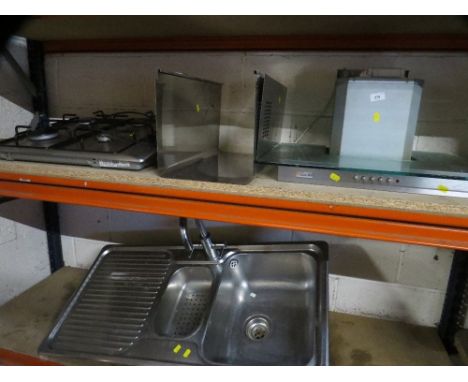 A stainless steel gas hob / extraction unit together with a sink 