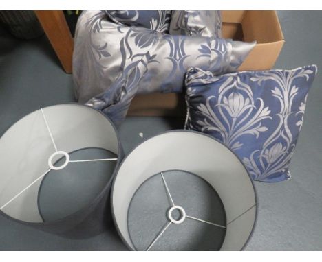 Two faux indoor pot plants together with cushions, curtains and lamp shades