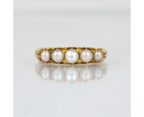 An early 20th century pearl ring, the five graduated pearls within yellow metal claw setting edge leading to plain polished s