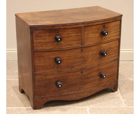 An early 19th century mahogany bowfront chest of drawers, formed with two short over two long graduated and cock beaded drawe