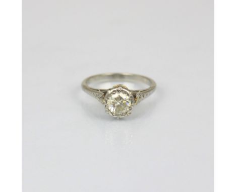An early 20th century diamond solitaire, the round cut diamond within white metal illusion setting, leading to grooved should