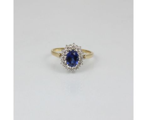 An Edwardian style synthetic sapphire cluster ring, the central blue stone within surround of white stones, in white metal mo