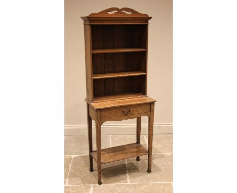 A 1920's honey oak open bookcase on stand, of cottage proportions, the pierced pediment over two shelves, upon the base forme