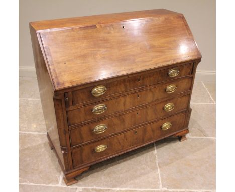 A George III mahogany bureau, the fall front opening to a compartmented interior, and a central door inlaid with a conch shel