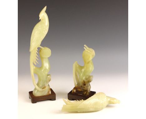 A pair of Chinese carved Jade phoenix birds, 20th century, modelled atop a tree stump, with hardwood bases, 34cm high, boxed 