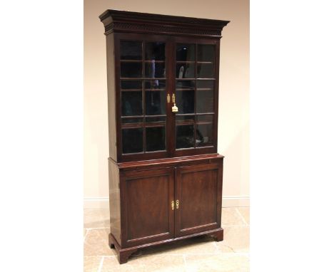 George III mahogany glazed library bookcase, later converted to a gun cabinet, the moulded dentil cornice over a blind fretwo