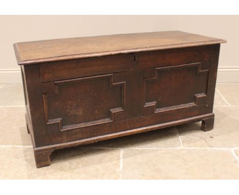 A Charles II oak coffer, the hook and eye hinged twin plank cover above geometrically moulded twin panels, all upon bracket f