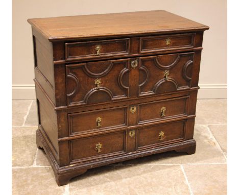 A Jacobean and later oak chest of drawers, the moulded three plank top over an arrangement of four long oak lined drawers, ea