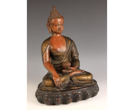 A South East Asian cold-cast bronze model of buddha, modelled seated in dhyanasana, holding a small vessel in his left hand, 
