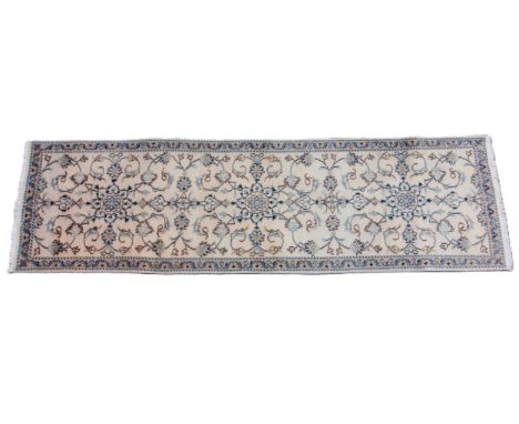 A fine hand woven ivory ground Persian Nain runner, the central field with an all over trailing design, 279cm x 79cm