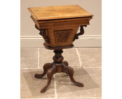 A Victorian walnut work or sewing table, the moulded hinged cover opening to a compartmented interior with central covered we