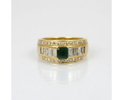An emerald and diamond dress ring, the central emerald cut emerald within baguette cut diamond surround and further border of