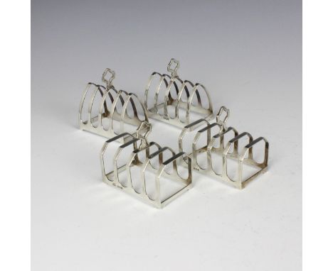 A pair of silver toast racks, Emilie Viner, Sheffield 1962, of arched form and shaped thumbpiece, 8cm high, with a further pa