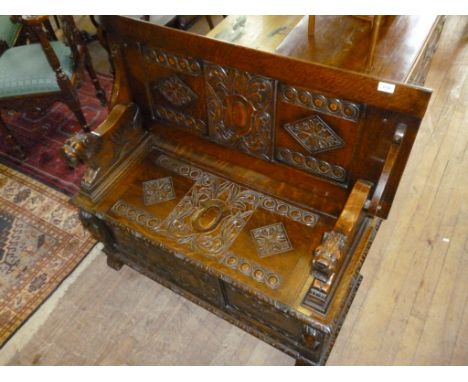 A good quality solid oak monks bench, having carved and panelled lift up seat.