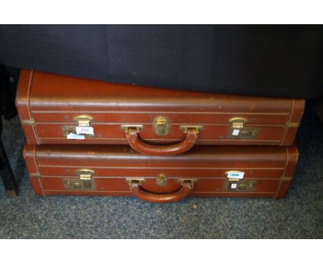 Two vintage leather suitcases.