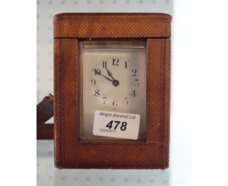 A French brass bound carriage clock with arabic numerals set within original leather case