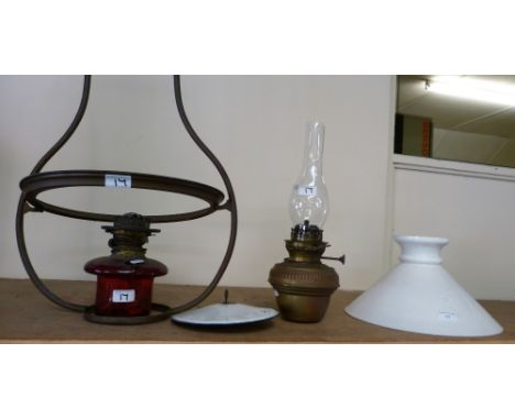 A brass oil lamp with chimney together with a hanging oil lamp with white glass shade and cranberry glass resevoir (2)