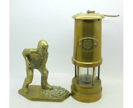 A brass miner's lamp and a brass figure of a miner