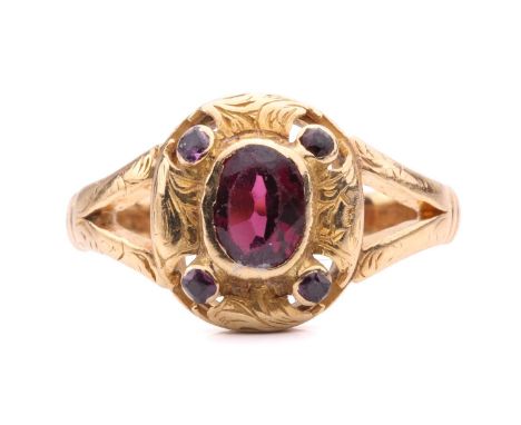 A Victorian garnet ring, set with an almandine garnet in an engraved scrolling foliate design set with paste, with engraved s